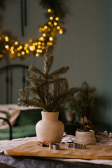 Christmas decor on the table in the house. Spruce branches in a vase