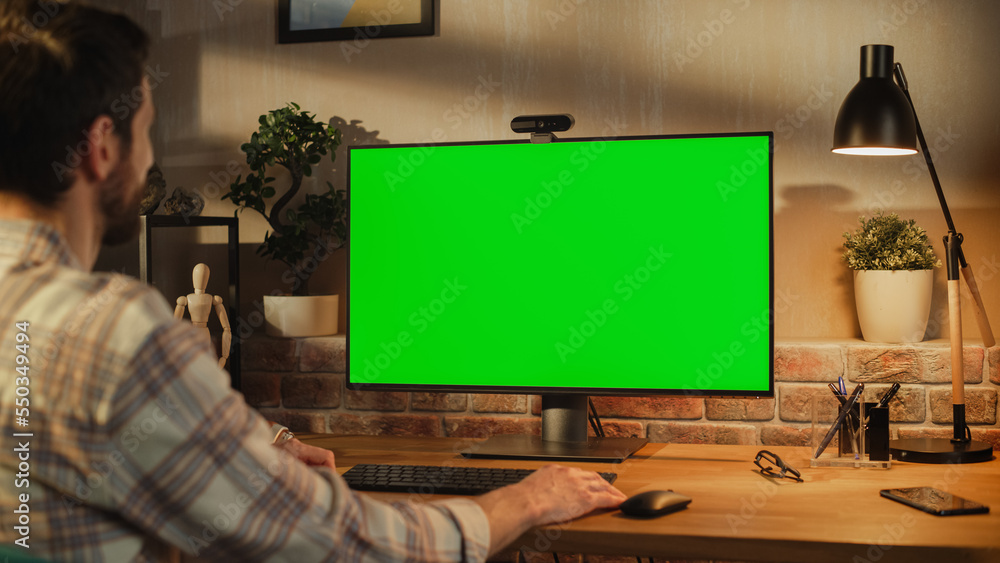 Poster freelance designer working remotely at home on desktop computer with green screen display. creative 