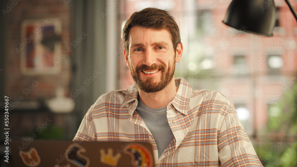 Aufkleber portrait of a handsome bearded young adult man using laptop computer with stickers on the back in cr