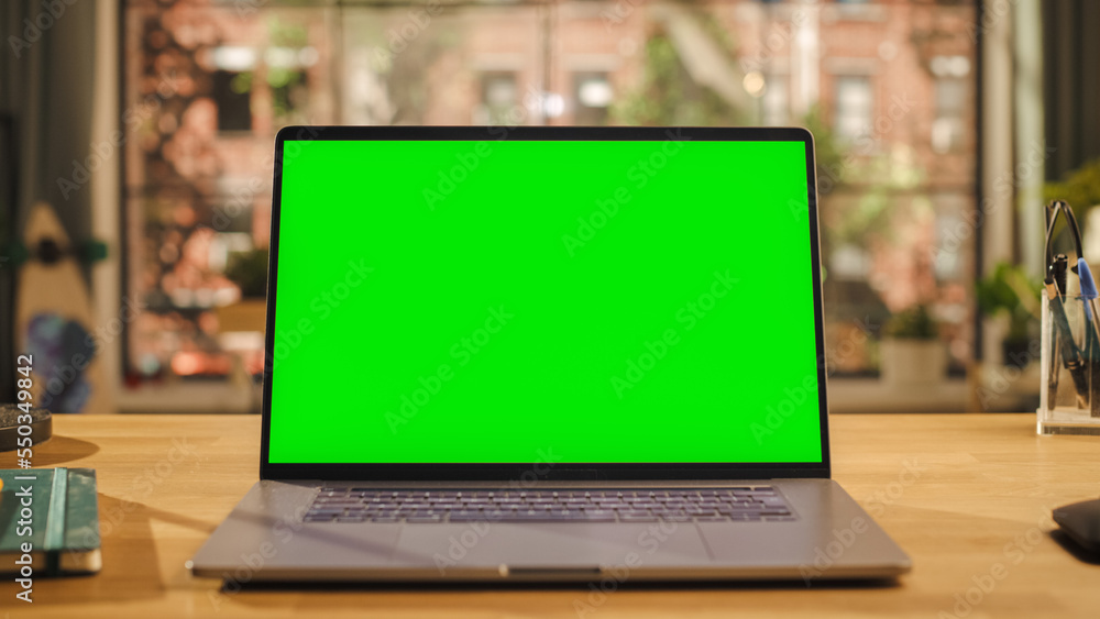 Aufkleber laptop computer display with mock up green screen standing on a wooden desk in living room. chroma k