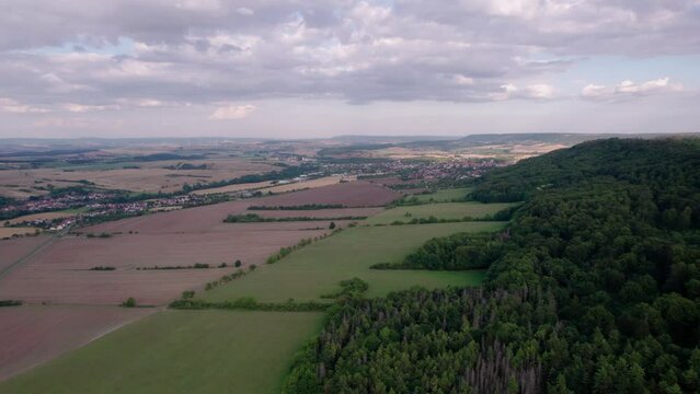 Aer ial view of a German village surrounded by meadows, farmland and forest in Germany.