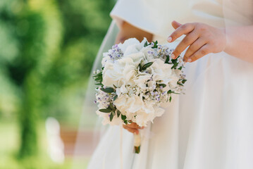 Wedding bouquet with white hydrangea in the hands of the bride