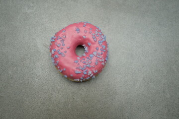 Pink sweet donut on the grey table