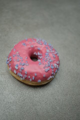 Pink sweet donut on the grey table