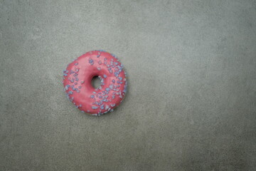 Pink sweet donut on the grey table