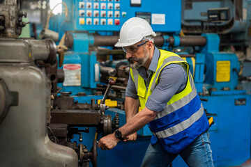 Technicians wearing gloves, helmets, working in an industrial factory. Male with protective gloves welding in a factory.