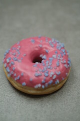 Pink sweet donut on the grey table