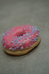 Pink sweet donut on the grey table