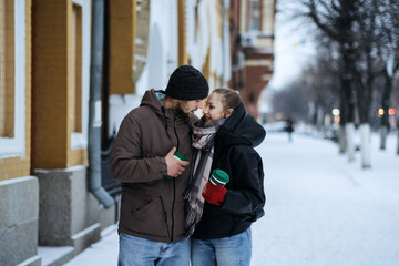 Winter Date Ideas to Cozy Up. Cheap First-Date Ideas for Winter Love dating outdoors. Cold season dates for couples. Young couple in love hugging and kissing in winter street and park.