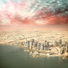 Fototapeta na wymiar Aerial view of Doha skyline from airplane. Corniche and modern buildings, Qatar