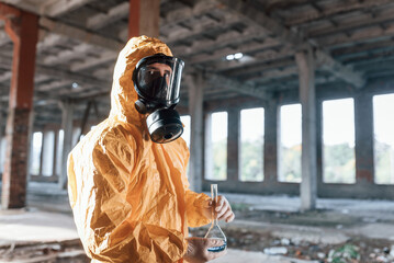 Portrait of man dressed in chemical protection suit that is in the ruins of the post apocalyptic...