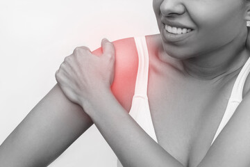 Shoulder injuries. Cropped shot of a young caucasian woman holding a shoulder in her hand isolated...