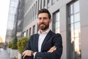 Confident glad young european male ceo manager with beard crossed his arms over chest, looks at empty space