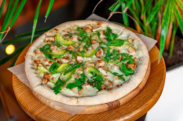 Delicious pizza with grilled chicken, avocado, and arugula.