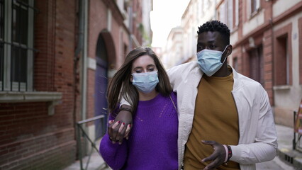 Obraz premium Interracial couple wearing covid-19 face mask walking outside3