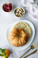 Fresh croissant and fruit on a light background. Delicious breakfast or snack