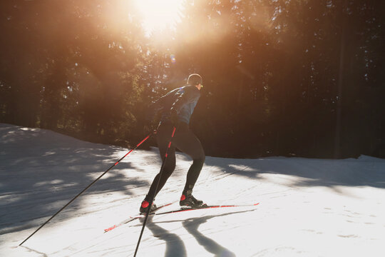 Nordic skiing or Cross-country skiing classic technique practiced by man in a beautiful panoramic trail at morning.