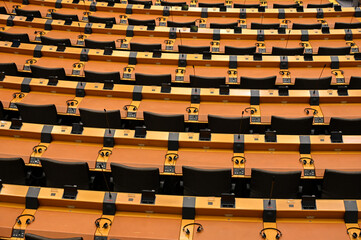 Brussels, Belgium: Many headphones on table in Plenary room in EU parliament. Seats in Assembly room of European Parliament. Institutions of European Union in Bruxelles.  - obrazy, fototapety, plakaty