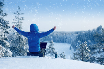 Winter freelance. Happy man uses laptop outdoor in winter.