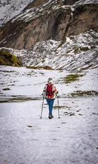 Fotobehang Marcheuse dans la montagne enneigée © Laura Truffaut