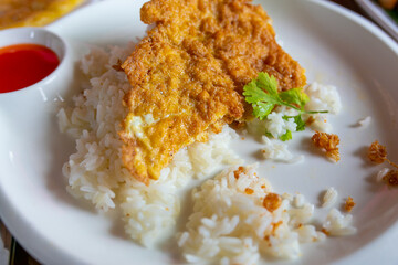 Creamy omelet on rice with fried chicken.	