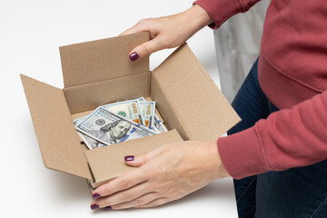 a man holds a box in which dollars