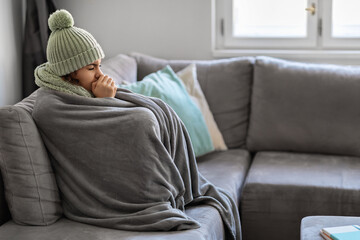 Energy Crisis. Portrait Of Woman Covered In Warm Blanket Sitting On Couch