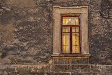 Part of the decoration of the facade of the building and the material from which it is built;  
old wall with a window