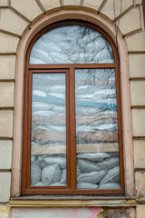Part of the decoration of the facade of the building and the material from which it is built;  
the window is covered with sandbags to protect against damage