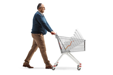 Full length profile shot of a mature man walking and pushing a shopping cart with a bar chart