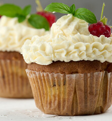 Baked cupcakes with white butter cream on the table, delicious dessert