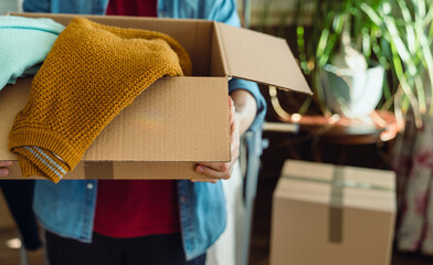 Man holding box with clothes, concept of clothes donation