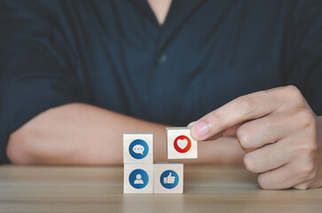 Hand putting wooden cube symbol of Social media and digital online concept. living on vacation and playing social media. Social Distancing ,Working From Home concept