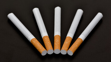 Cigarettes and cigarette butts on a black background.