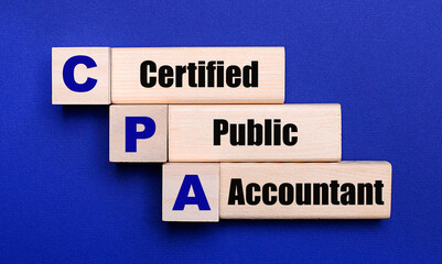 On a bright blue background, light wooden blocks and cubes with the text CPA Certified Public Accountant