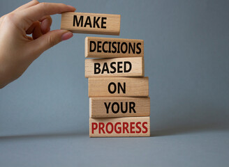 Decision and Progress symbol. Concept words Make decisions based on your progress on wooden blocks. Businessman hand. Beautiful grey background. Business concept. Copy space.