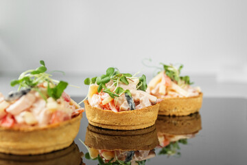 Delicious appetizer with tartlet and salad. Food, restaurant and event concept.