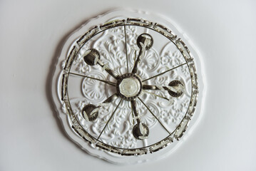 Fototapeta na wymiar Round elegant chandelier seen from below on a white ceiling.