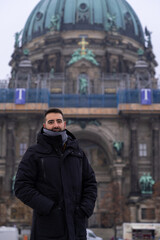 Fototapeta na wymiar Attractive young male tourist with beard and berlin cathedral in the background