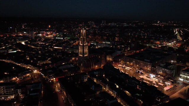 The Saint Eusebius Church or Grote Kerk in Arnhem city in the Netherlands by night, Aerial drone. City center, skyline and infrastructure, city center. Night time overhead view.