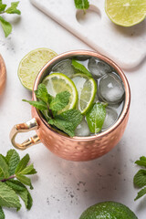 Moscow mule alcoholic cocktail in copper mug with lime, mint and cucumber