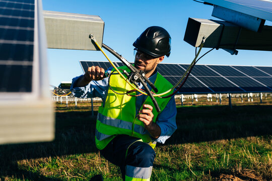 Installer working with solar panels in countryside