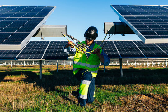 Installer working with solar panels in countryside