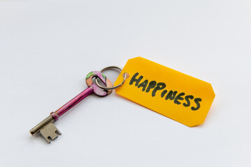 A key to happiness concept with a key and the word happiness isolated in a white background.
