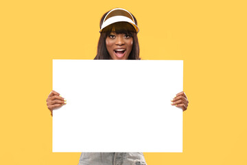 Attractive female is holding a white board on isolated yellow background.
