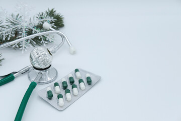 Christmas tree, stethoscope, silver ball, blister with capsules on white background with copy...