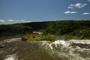 The Iguazu falls in Misiones, Argentina. View of San Martin fall. The waterfall's white water falling along the rocky precipice into the jungle.