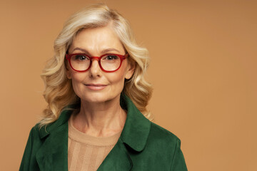 Studio portrait of confident mature businesswoman wearing stylish red  eyeglasses isolated on background. Successful business concept 