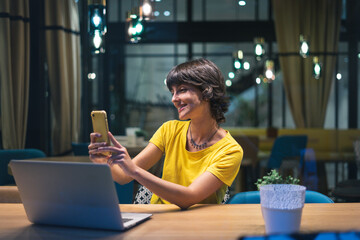 young woman with laptop and smartphone inside a coffee shop