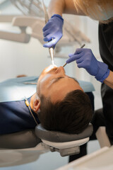 Fototapeta premium Young man at the dentist. Dentist woman. Dental office.